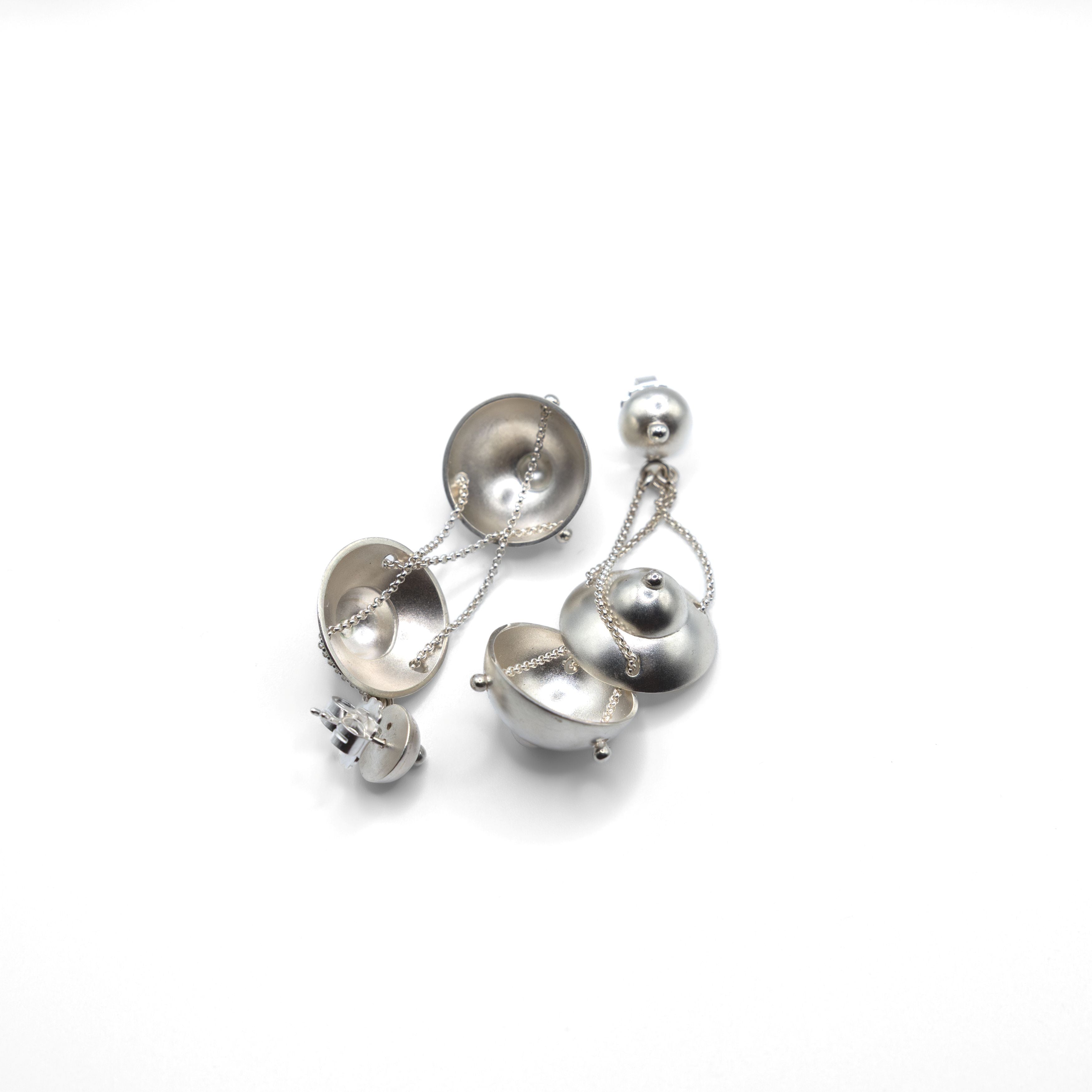 Deconstructed Myrrha earring showing its components: stud, chains, and open bell pendant.