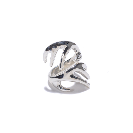 A shiny silver ring with a stylized, branching design resembling reindeer antlers wraps around the finger.