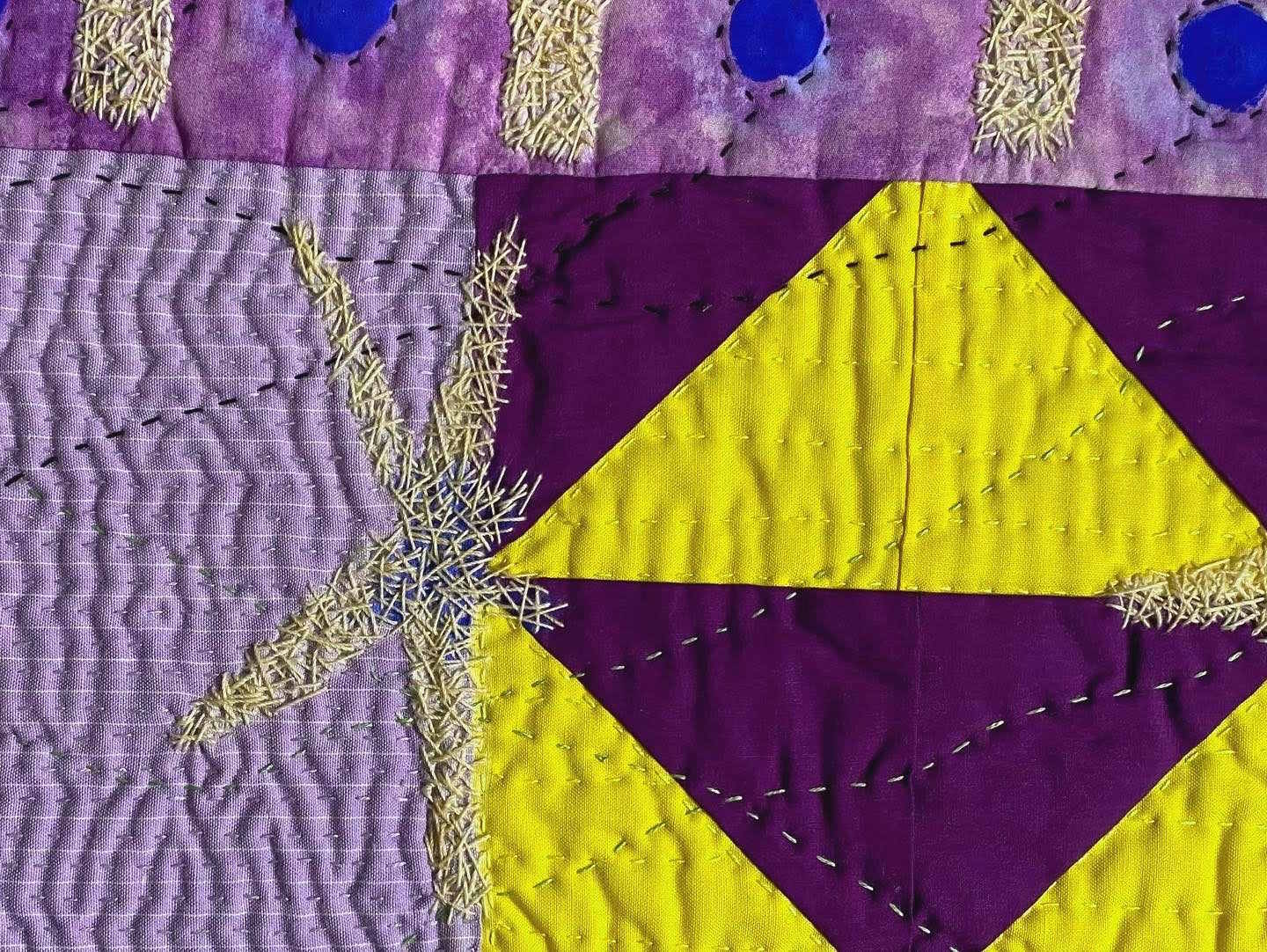 Geometric textile artwork with purple and yellow blocks, diverse stitching, and textured fabric segments.
