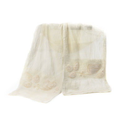 A soft, textured Merino wool shawl with delicate floral embroidery on a plain background.
