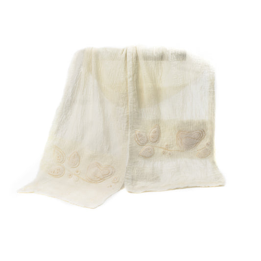A soft, textured Merino wool shawl with delicate floral embroidery on a plain background.