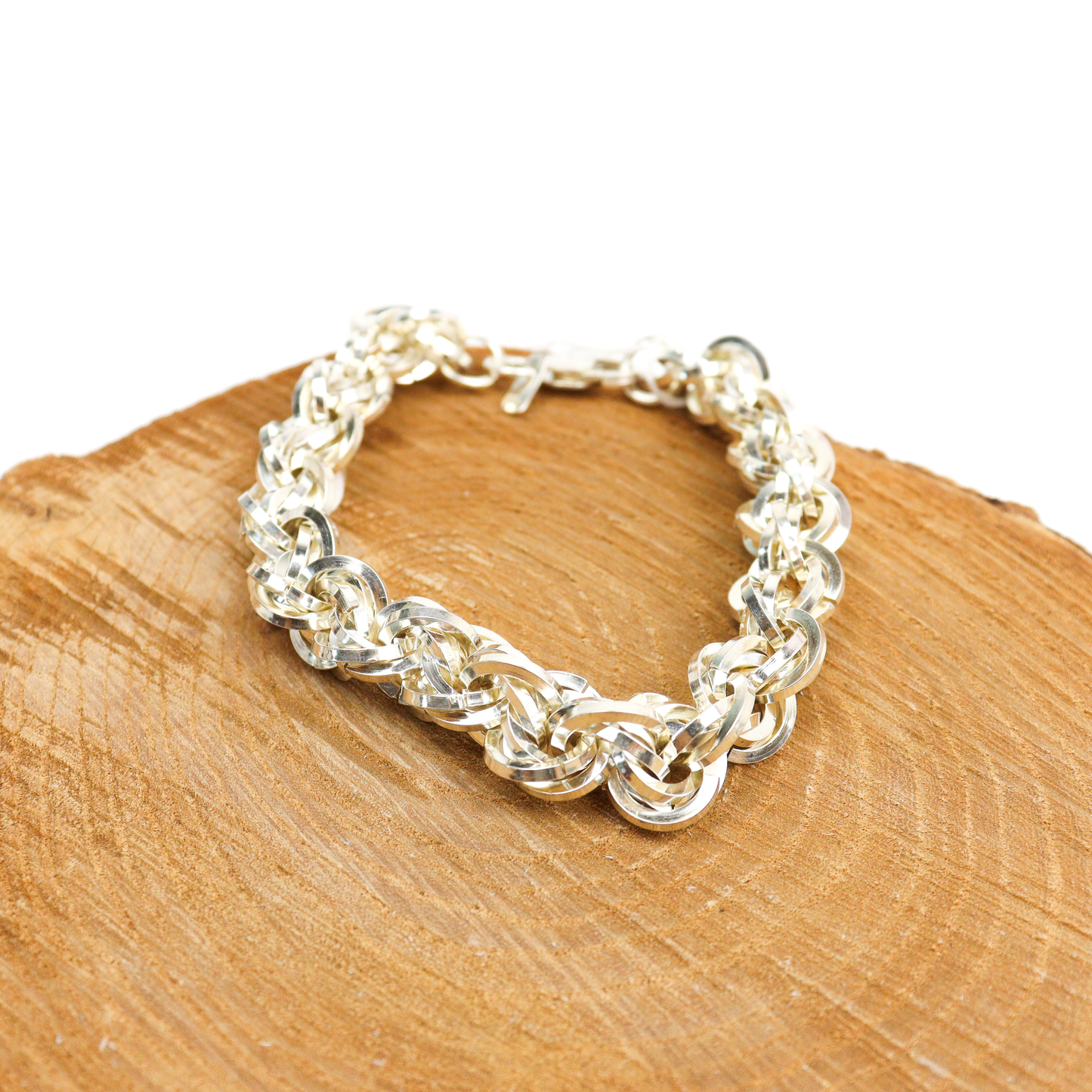 Heavy Kriss Kross Bracelet displayed on a wooden surface, highlighting the intricate silver weave.