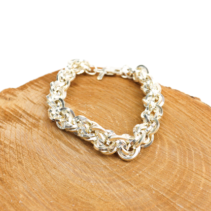 Heavy Kriss Kross Bracelet displayed on a wooden surface, highlighting the intricate silver weave.