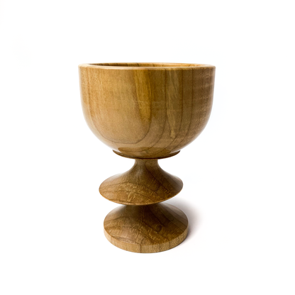 A light brown maple goblet with a rounded bowl and a twisted stem.