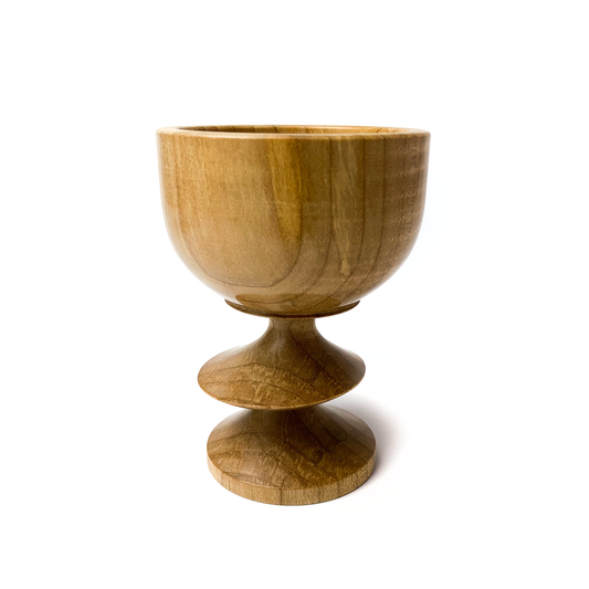 A light brown maple goblet with a rounded bowl and a twisted stem.