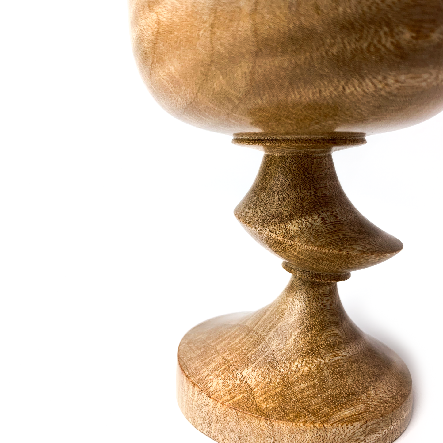 Close-up of a light brown maple goblet with a twisted stem.