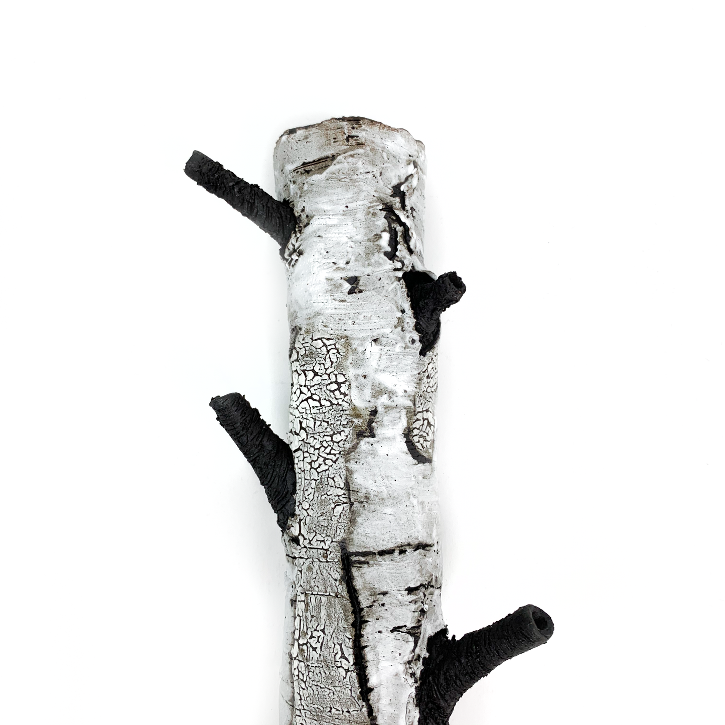 A birch bark textured wall hanging with three protruding black branches.