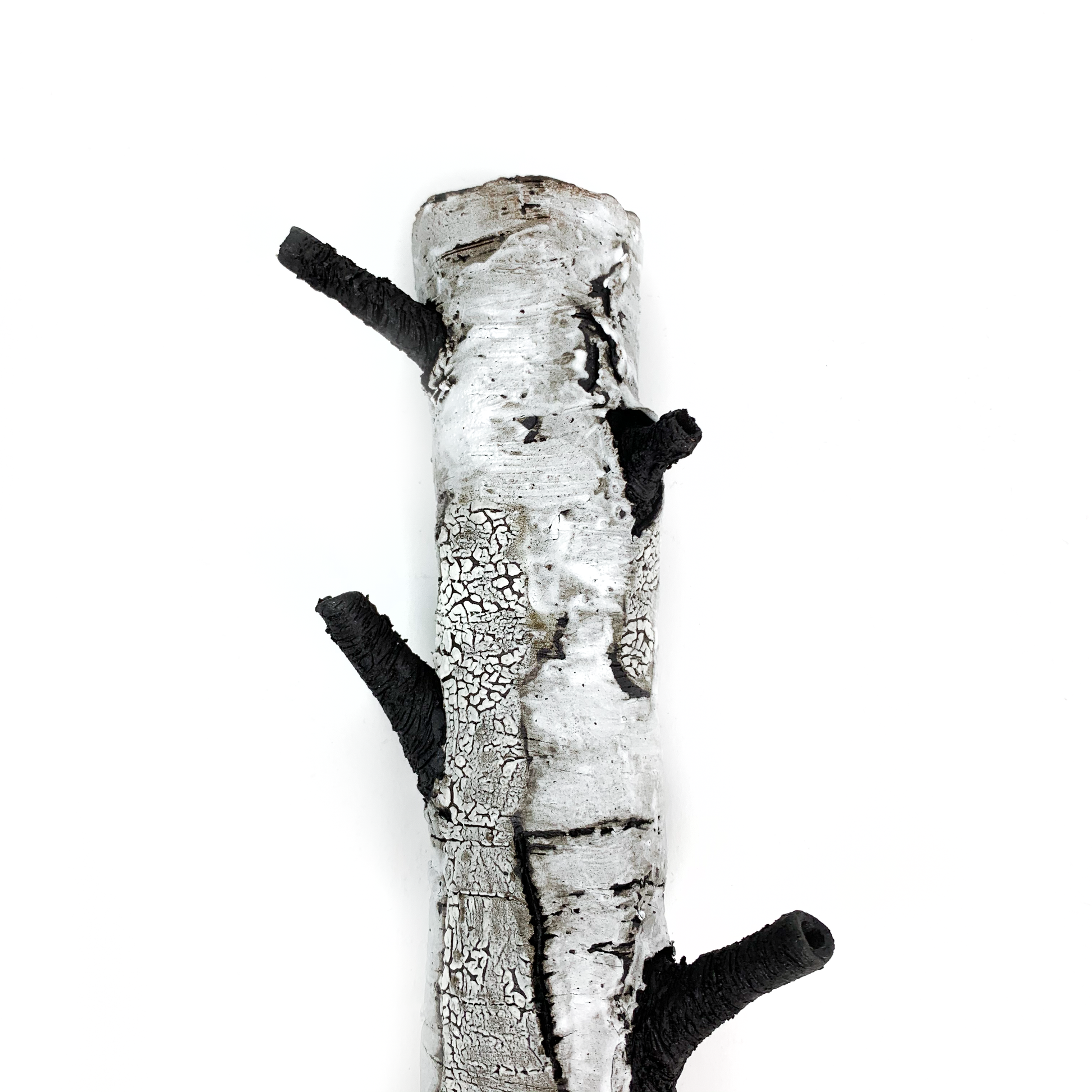 A birch bark textured wall hanging with three protruding black branches.