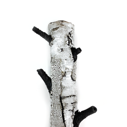 A birch bark textured wall hanging with three protruding black branches.