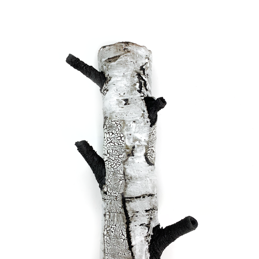 A birch bark textured wall hanging with three protruding black branches.