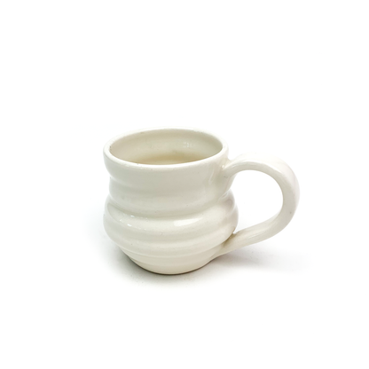 A ceramic mug with horizontal ridges around the body and a curved handle on the right side.