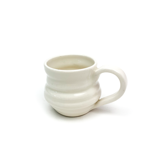 A ceramic mug with horizontal ridges around the body and a curved handle on the right side.
