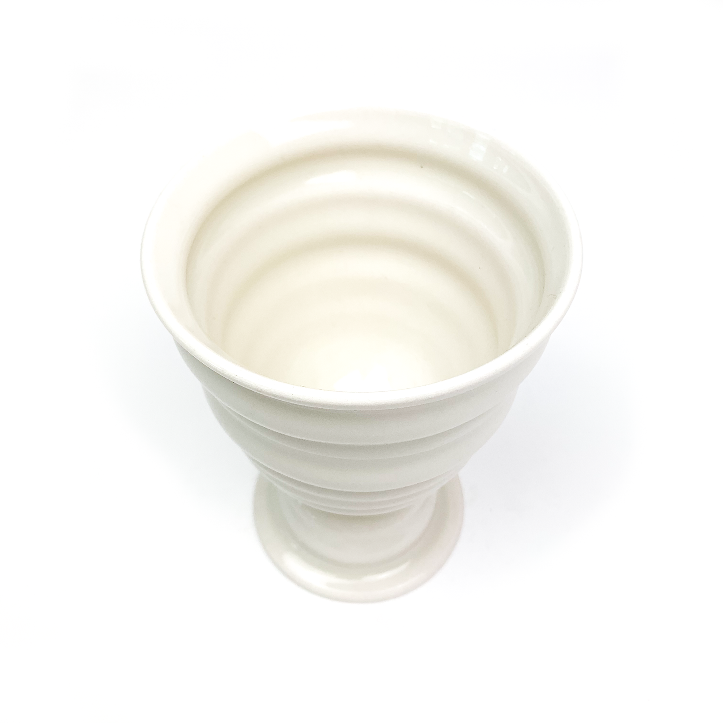 Overhead view of a ceramic goblet revealing its ridged interior, stem with rings, and circular base.