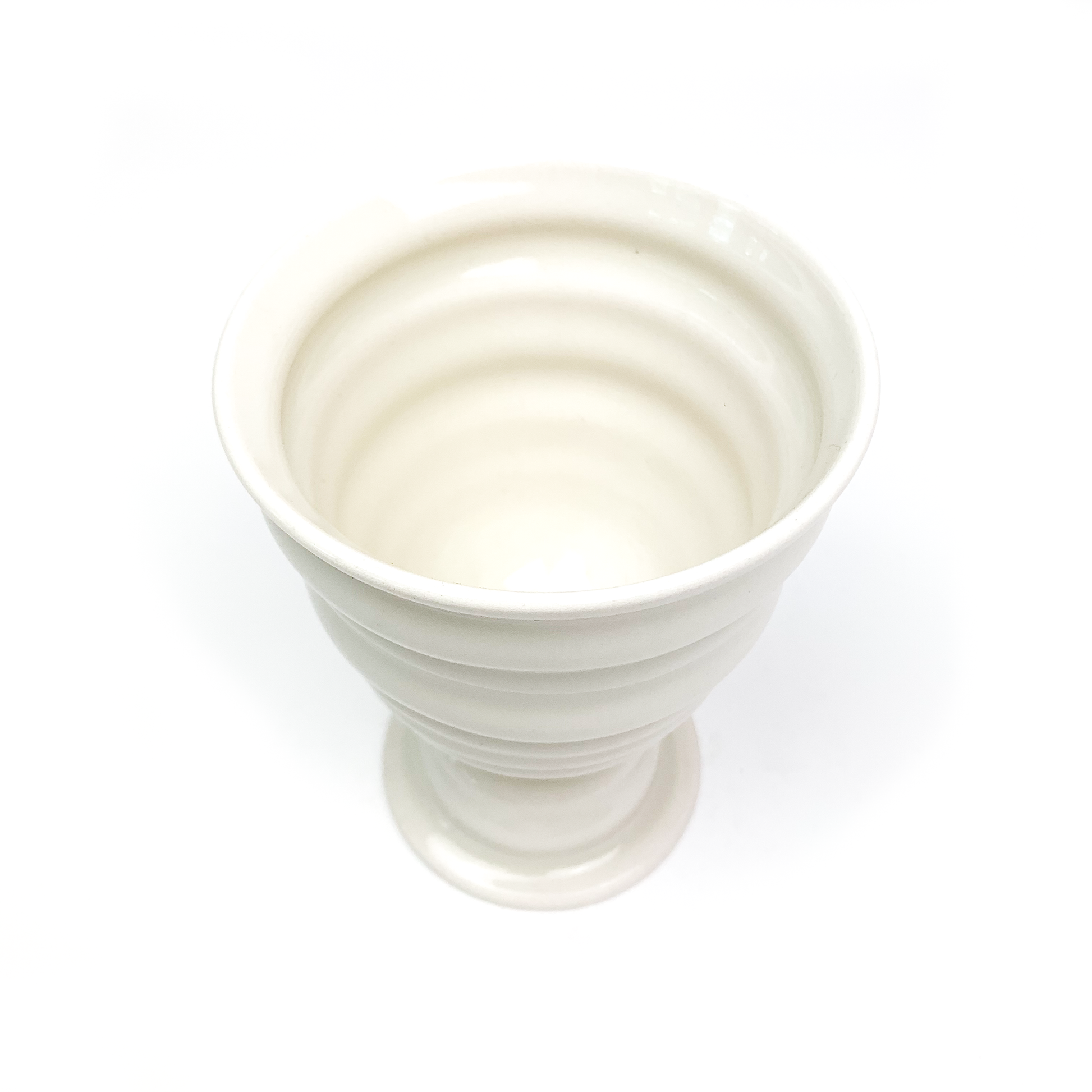 Overhead view of a ceramic goblet revealing its ridged interior, stem with rings, and circular base.