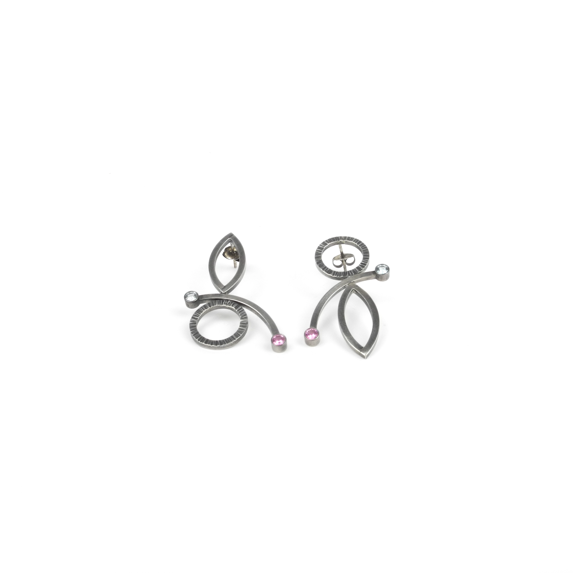 A pair of abstract metallic earrings with circles, ovals, curves, and small pink and clear gemstones.