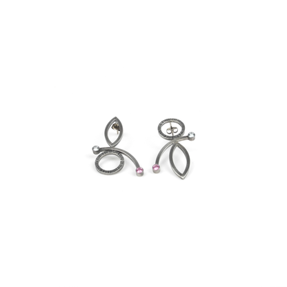 A pair of abstract metallic earrings with circles, ovals, curves, and small pink and clear gemstones.