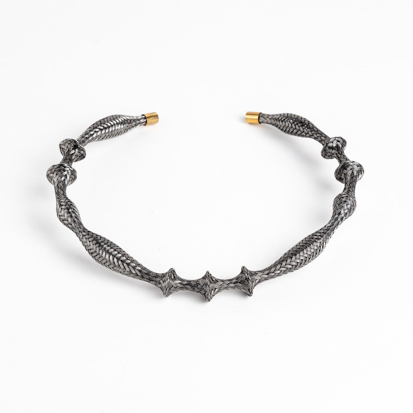 Curved stainless steel braided necklace with gold end caps on a white background, angled view.