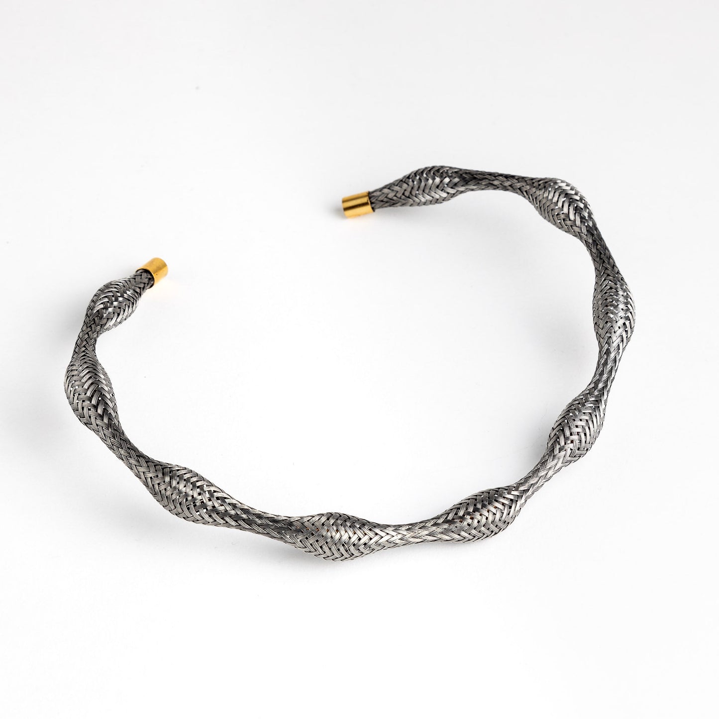 Curved stainless steel braided necklace with gold end caps, angled.