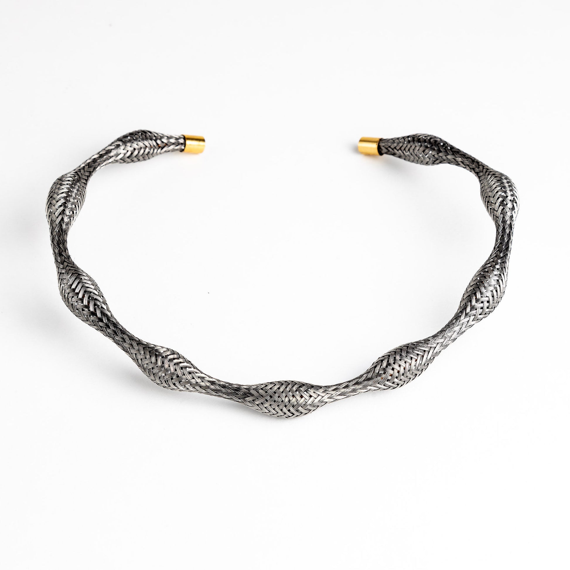 Curved stainless steel braided necklace with gold end caps, angled.
