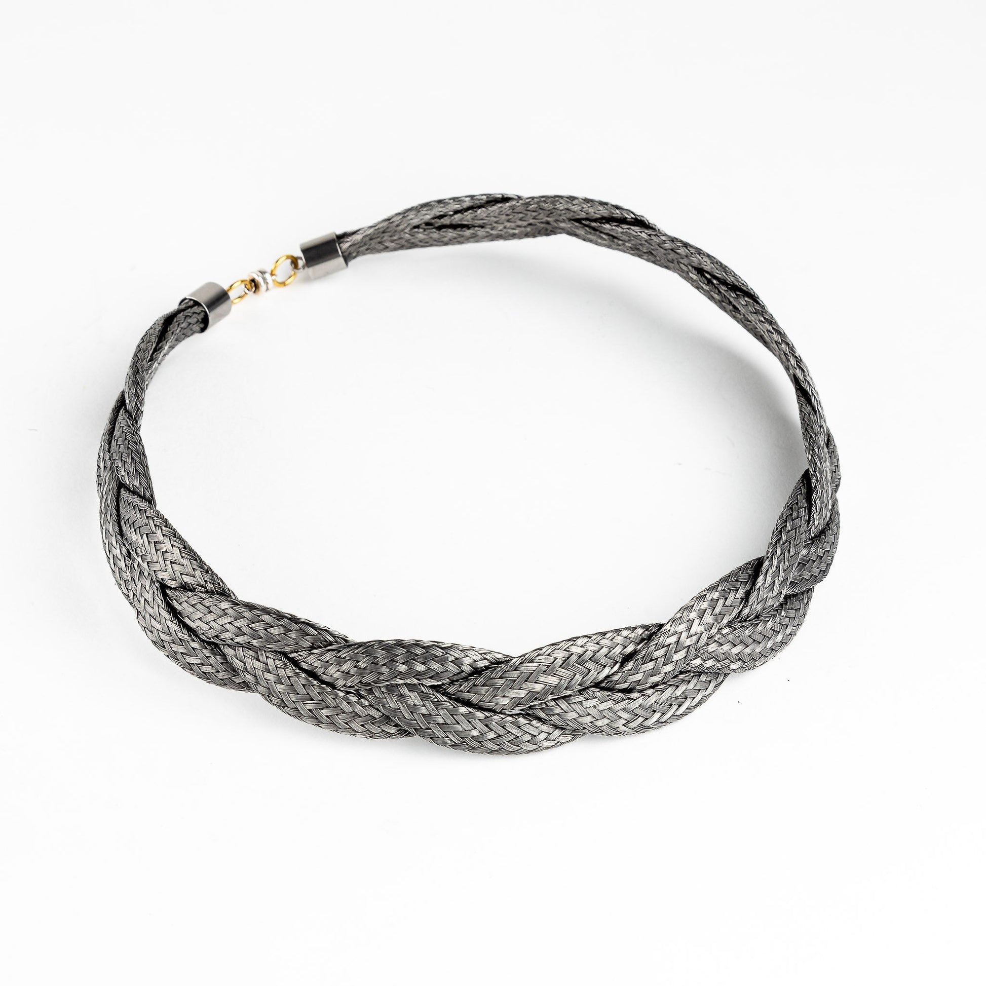 Braided stainless steel necklace with gold clasp, slightly angled, on a white background.