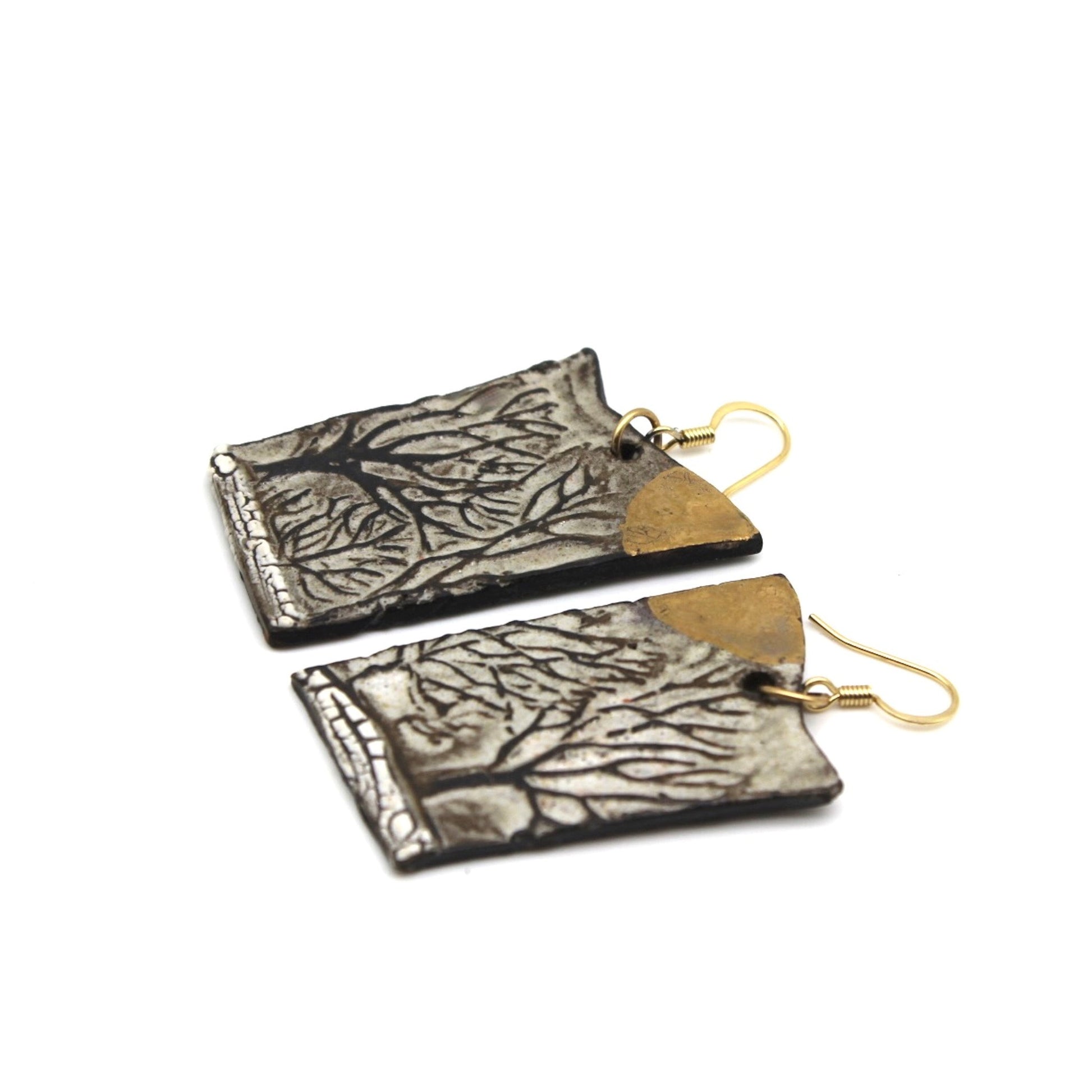 Two rectangular earrings with tree-like patterns, gold hooks, and gold accents at the top corner.