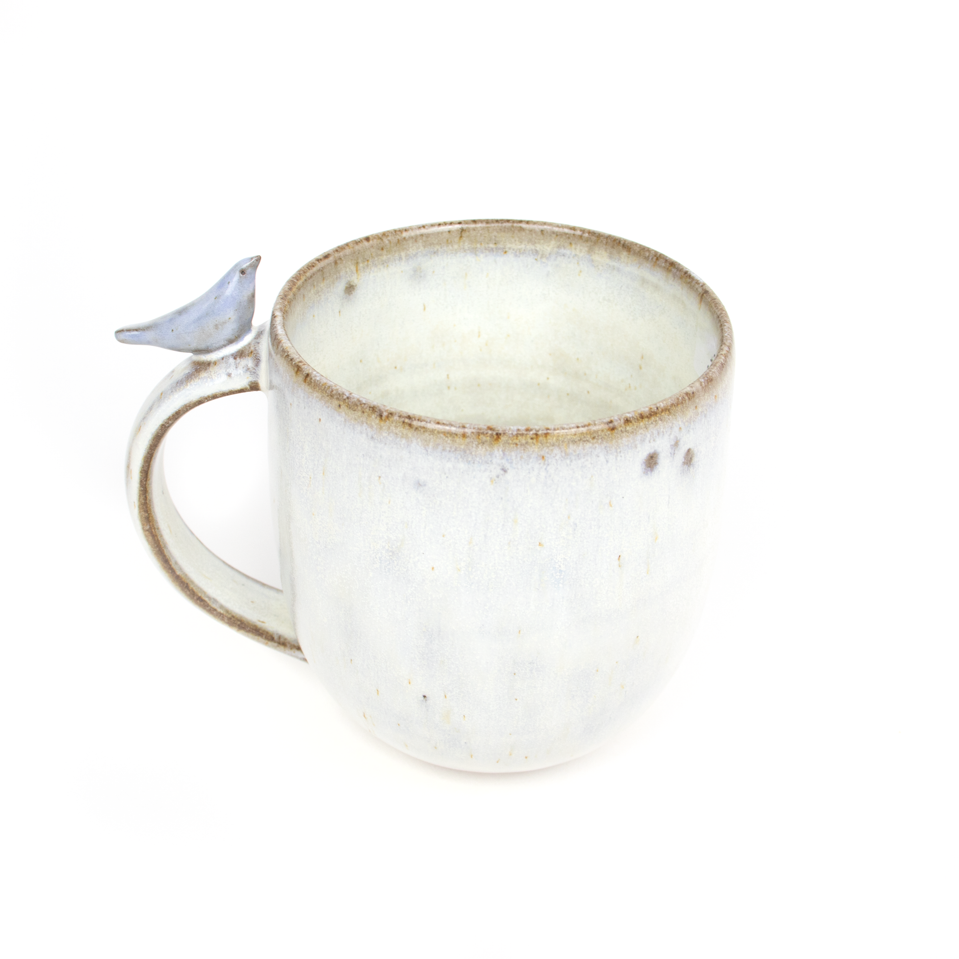 Handmade pottery mug from a pottery shop, showcasing a delicate, sculpted bird on its handle. The mug has a rustic, textured finish.