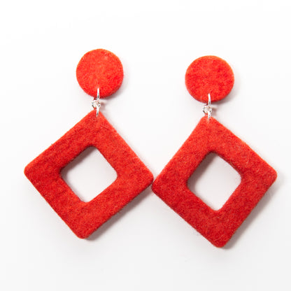 Two red felt earrings with silver hooks. Each earring has a small circle above a larger, hollow diamond shape.
